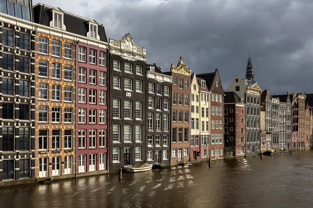 Les maisons colorées du Damrak au bord de l’eau à Amsterdam