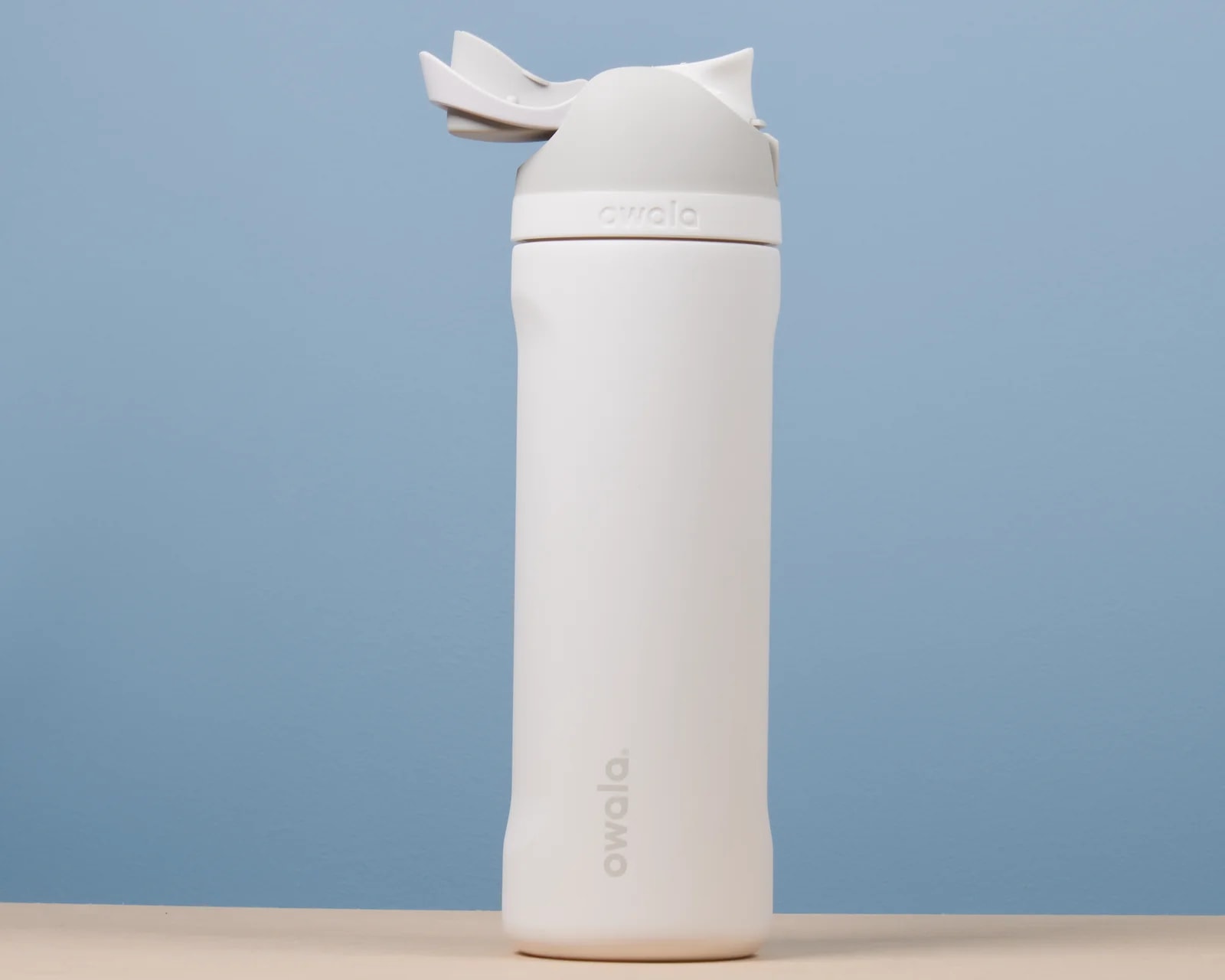 Close-up of the lid and carry loop on the Owala FreeSip 24 oz bottle in Shy Marshmallow